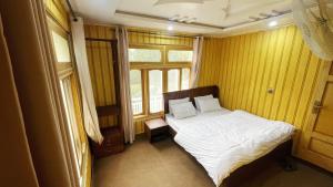 a small bedroom with a bed and a window at Alpine Resort Khaplu in Khaplu