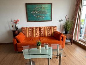 a living room with a couch and a table at Ferienwohnung De Kraan in Dorum-Neufeld