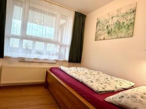 a bedroom with a bed and a window at Ferienwohnung De Kraan in Dorum-Neufeld