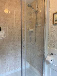 a shower with a glass door in a bathroom at Cobweb Cottage in Patrington +15 photos