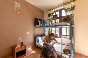 a man sitting in a room with a bunk bed at RWACHO Hostel The Base in Leh