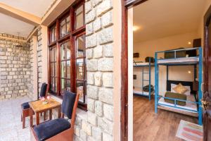a room with a brick wall and a bedroom with bunk beds at RWACHO Hostel The Base in Leh