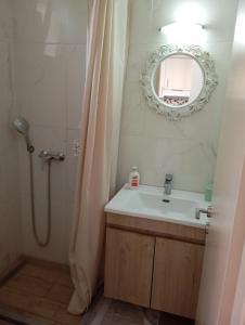a bathroom with a sink and a mirror at Nadia Studios in Kalamaki +18 photos