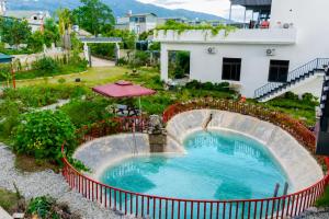 a small pool with a water fall in a yard at Mường Thanh Garden Stay in Dien Bien Phu