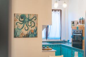a kitchen with an octopus painting on the wall at Appartamento La Pelosa in Stintino