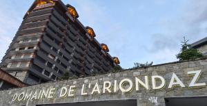 a sign on a wall with a tall building at Appartement l'Ariondaz in Courchevel