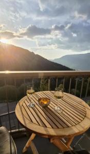 a wooden table with two wine glasses on a balcony at Appartement l'Ariondaz in Courchevel