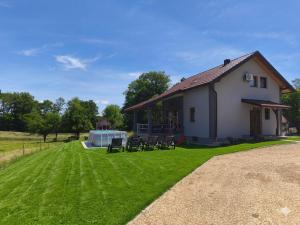 a house with a lawn with chairs and a tent at Kuća za odmor Marija in Gospić