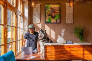 a man and a dog standing next to a table at RWACHO Hostel The Base in Leh