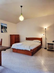 a bedroom with a wooden bed and a table at La Roccia Rossa in Stribugliano