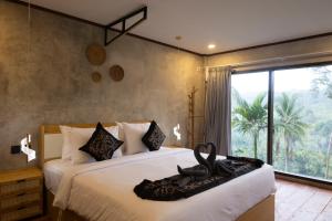 a bedroom with two beds and a large window at The Beauty Riptide in Karangasem