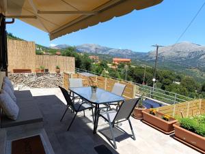 a table and chairs on a patio with a view at ainos cottage in Kambitsáta