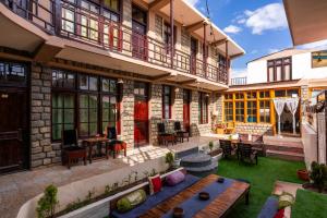 a courtyard of a building with a wooden bench at RWACHO Hostel The Base in Leh