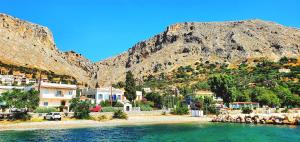 a group of houses on a beach next to a mountain at Chios Studios Kalamari in Vrontádos