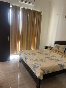 a bedroom with a bed and a window with curtains at Sai VVR homestay in Chennai