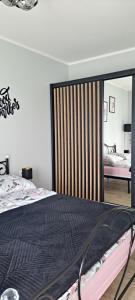 a bedroom with a bed and a large mirror at Apartament Różowa Perła in Przemyśl