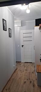 a room with a white door and a wooden floor at Apartament Różowa Perła in Przemyśl