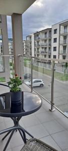 a balcony with a table and a car on a street at Apartament Różowa Perła in Przemyśl