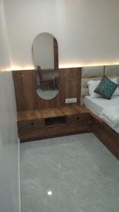 a bedroom with a mirror and a bed and a chair at Hotel shivam comfort in Hubli