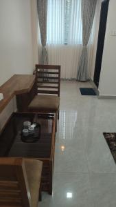 a living room with two chairs and a table at Hotel shivam comfort in Hubli