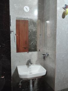 a bathroom with a sink and a mirror at Hotel shivam comfort in Hubli