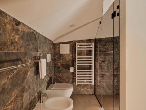 a bathroom with a toilet and a glass shower at Villa Giacomuzzi in Bolzano