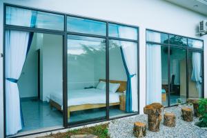 a bedroom with glass windows and a bed in it at Mường Thanh Garden Stay in Dien Bien Phu +37 photos