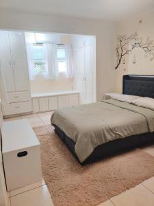 a white bedroom with a bed and a white cabinet at Cozy Stays in Oranjestad