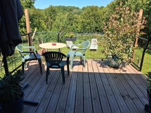 a wooden deck with a table and chairs on it at Gîte la Grange in Verdon +2 photos