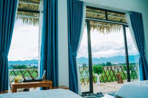 a bedroom with a bed and a window with a view at Mường Thanh Garden Stay in Dien Bien Phu