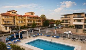 a hotel with a swimming pool in front of buildings at Jason Apartments in Paralia Katerinis