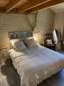a bedroom with a large white bed in a room at gîte chêne doré in Ribérac