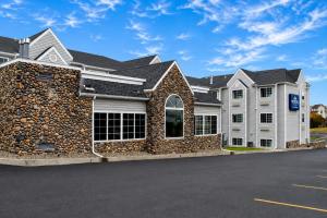 a large white house with a stone wall at Microtel Inn & Suites by Wyndham Bozeman in Bozeman