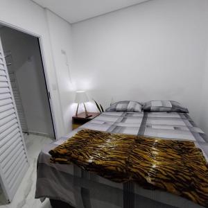 a white bedroom with a bed with a tiger blanket on it at Ap Interlagos apoia adversidade in São Paulo +11 photos