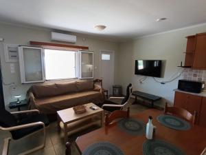 a living room with a couch and a table at ainos cottage in Kambitsáta