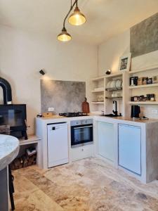 a kitchen with white cabinets and a stove top oven at La Roccia Rossa in Stribugliano