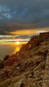 a castle on a hill with the sunset in the background at Apartman Biba in Lubenice