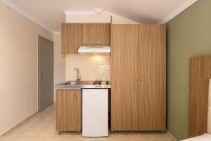 a kitchen with wooden cabinets and a sink at Jason Apartments in Paralia Katerinis