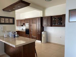a kitchen with wooden cabinets and a white refrigerator at Horizon 4 - Amman in Amman
