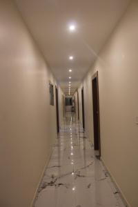 a long hallway with marble floors and walls at Hotel Relax inn in Chikmagalūr