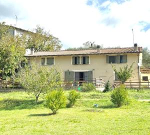 a house with a yard in front of it at Casa sul fiume con giardino e terrazza in Pianello