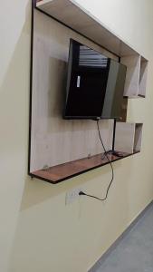 a flat screen tv hanging on a wall at Everspring Suites in Rohtak