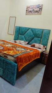 a large bed with an orange comforter in a room at Everspring Suites in Rohtak