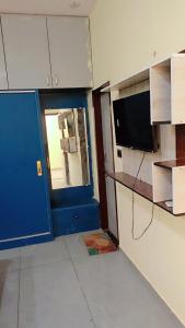 a room with a blue door and a tv in a room at Everspring Suites in Rohtak +15 photos