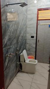 a bathroom with a toilet in a room at Everspring Suites in Rohtak