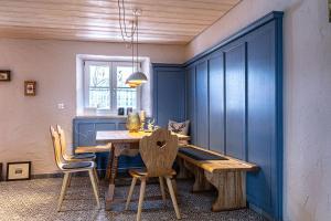 a dining room with a wooden table and chairs at Säntisblick in Oberstaufen