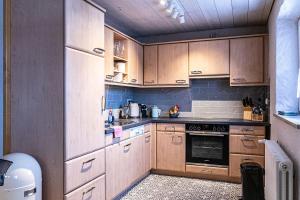 a kitchen with wooden cabinets and a stove top oven at Säntisblick in Oberstaufen +10 photos