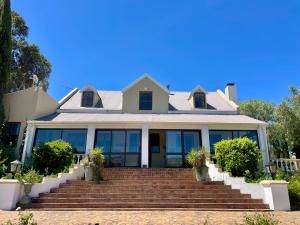 a house with glass windows and stairs at UnderHill Farm in Klipkraal