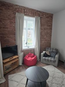 a living room with a brick wall at Kuninga Apartment in Old Town with Free Parking in Pärnu +7 photos
