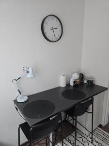 a black desk with a clock on a wall at Kuninga Apartment in Old Town with Free Parking in Pärnu